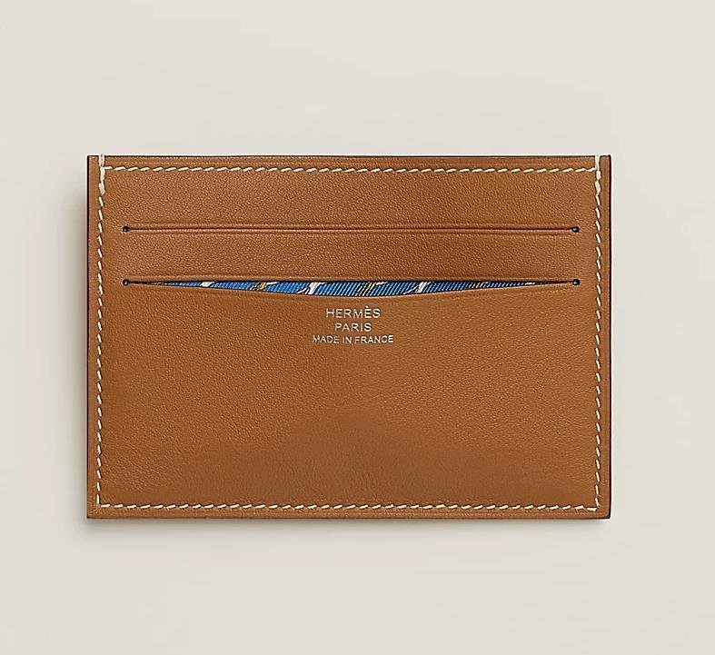 Luxury brown leather Hermes card holder with silver logo embossed on front